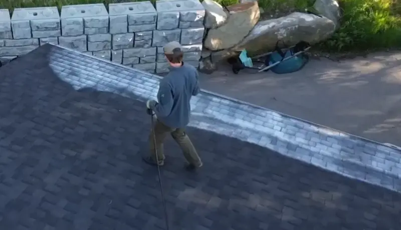 Technician applying GreenSoy roof revival treatment to asphalt shingles
